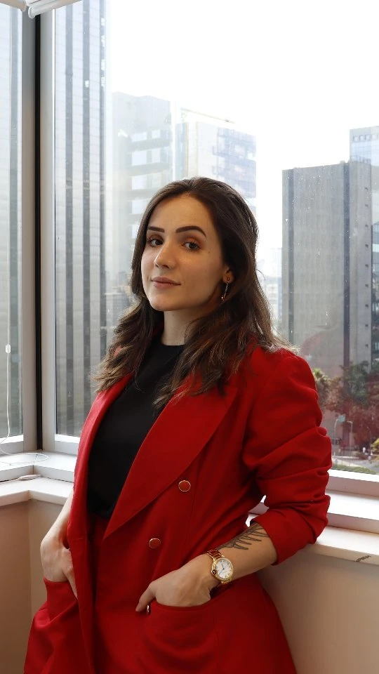 Fernanda Cosi de terno vermelho, retrato editorial com skyline de São Paulo ao fundo